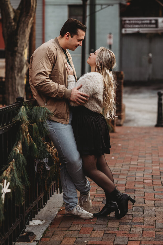 Maryland engagement photographer captures man and woman looking at one another during Christmas engagement photos