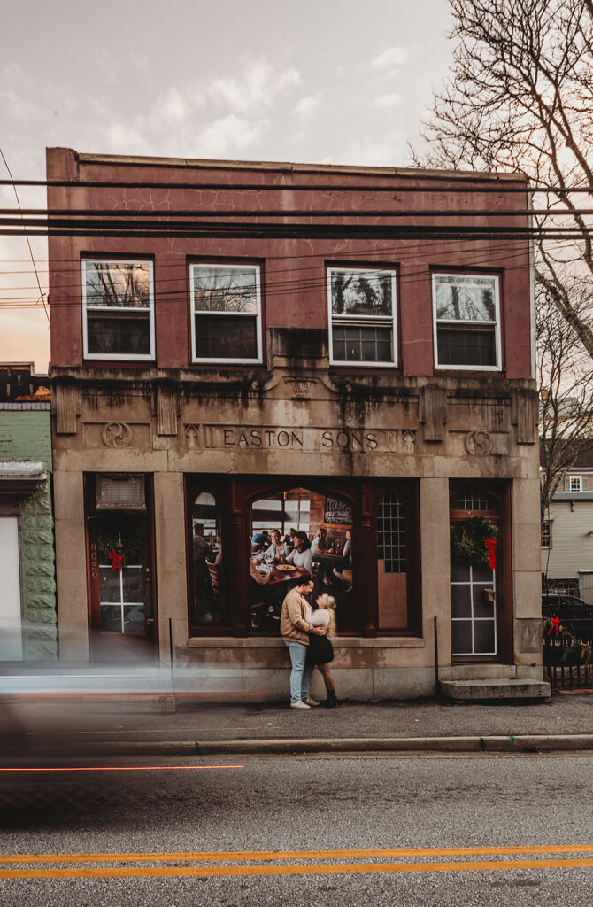 Maryland engagement photographer captures couple standing in front of store looking at one another