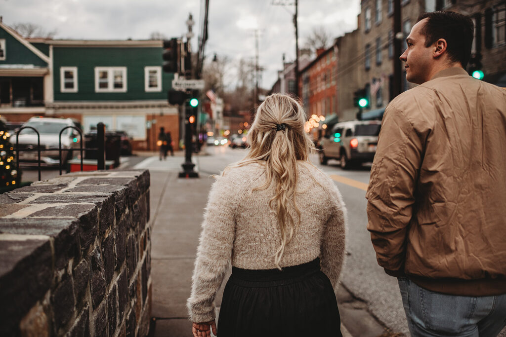 Maryland engagement photographer captures couple walking through Ellicott City during Christmas engagement photos