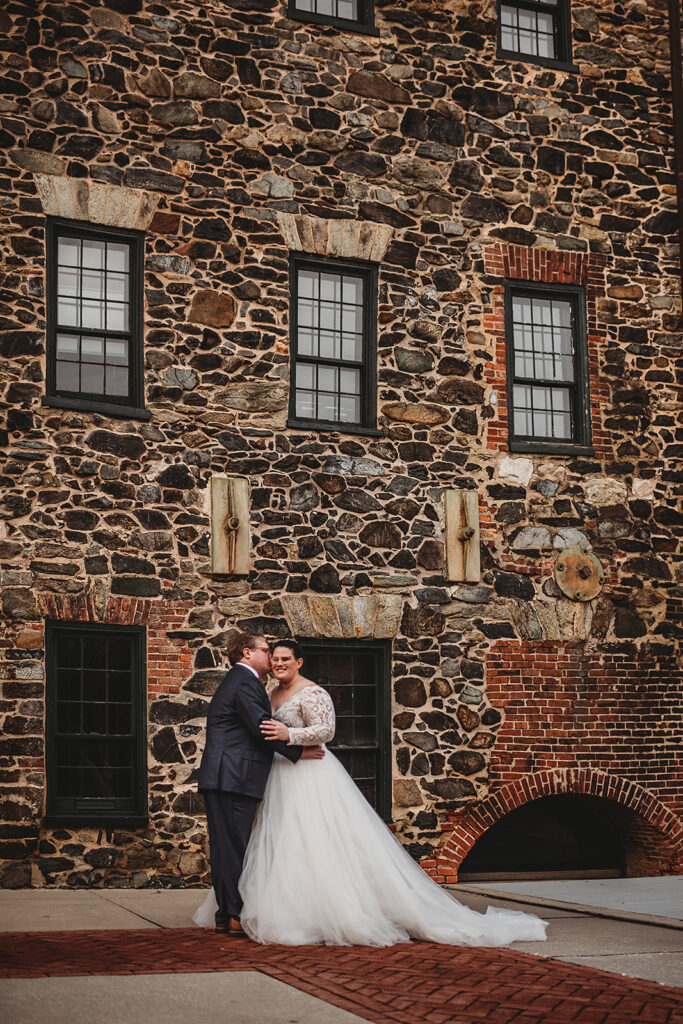 Baltimore wedding photographer captures couple embracing outside stone building