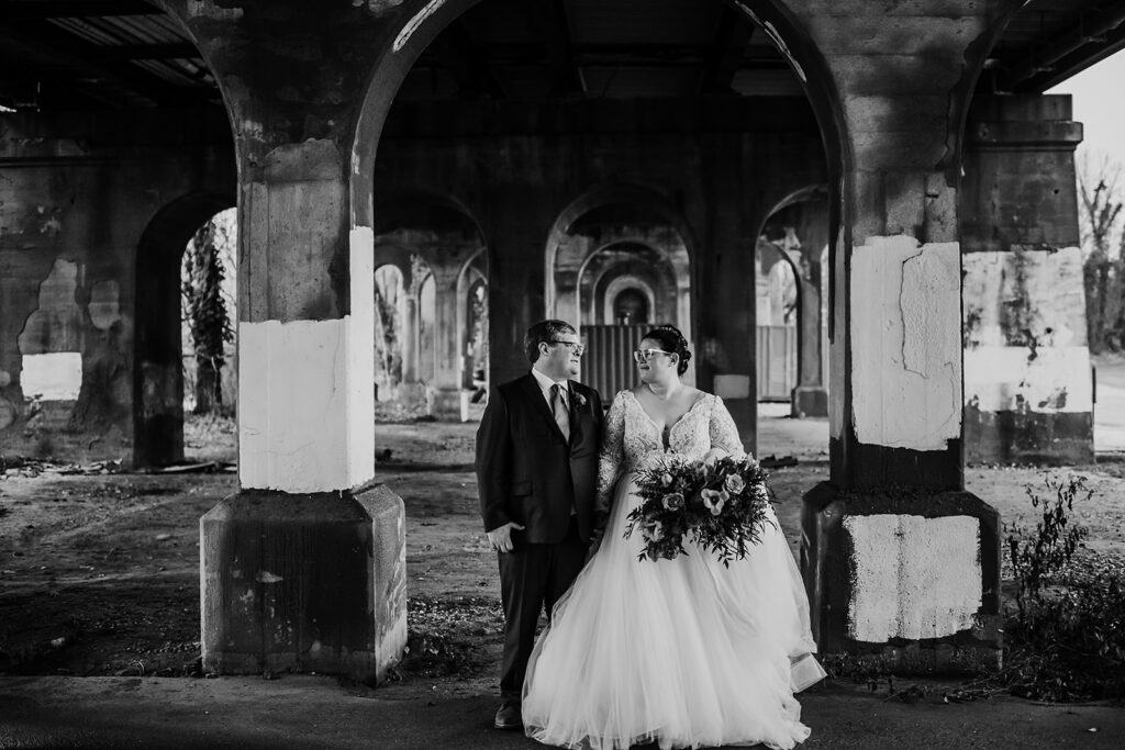 Baltimore wedding photographer captures black and white portrait of bride and groom holding hands