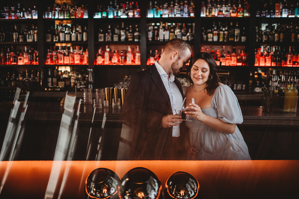 Baltimore Wedding Photographer captures man and woman celebrating engagement at bar