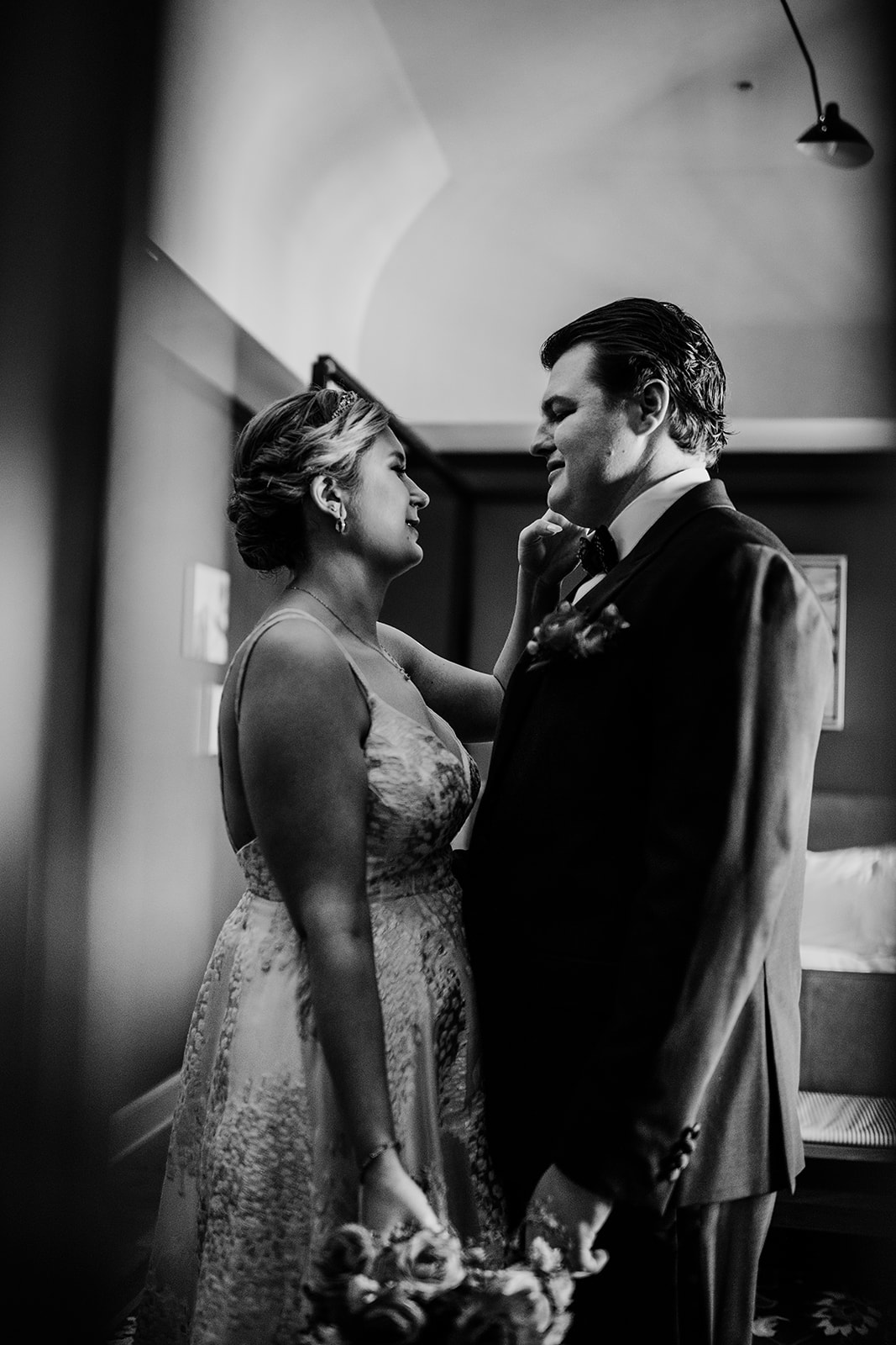 bride caresses grooms face during their first look