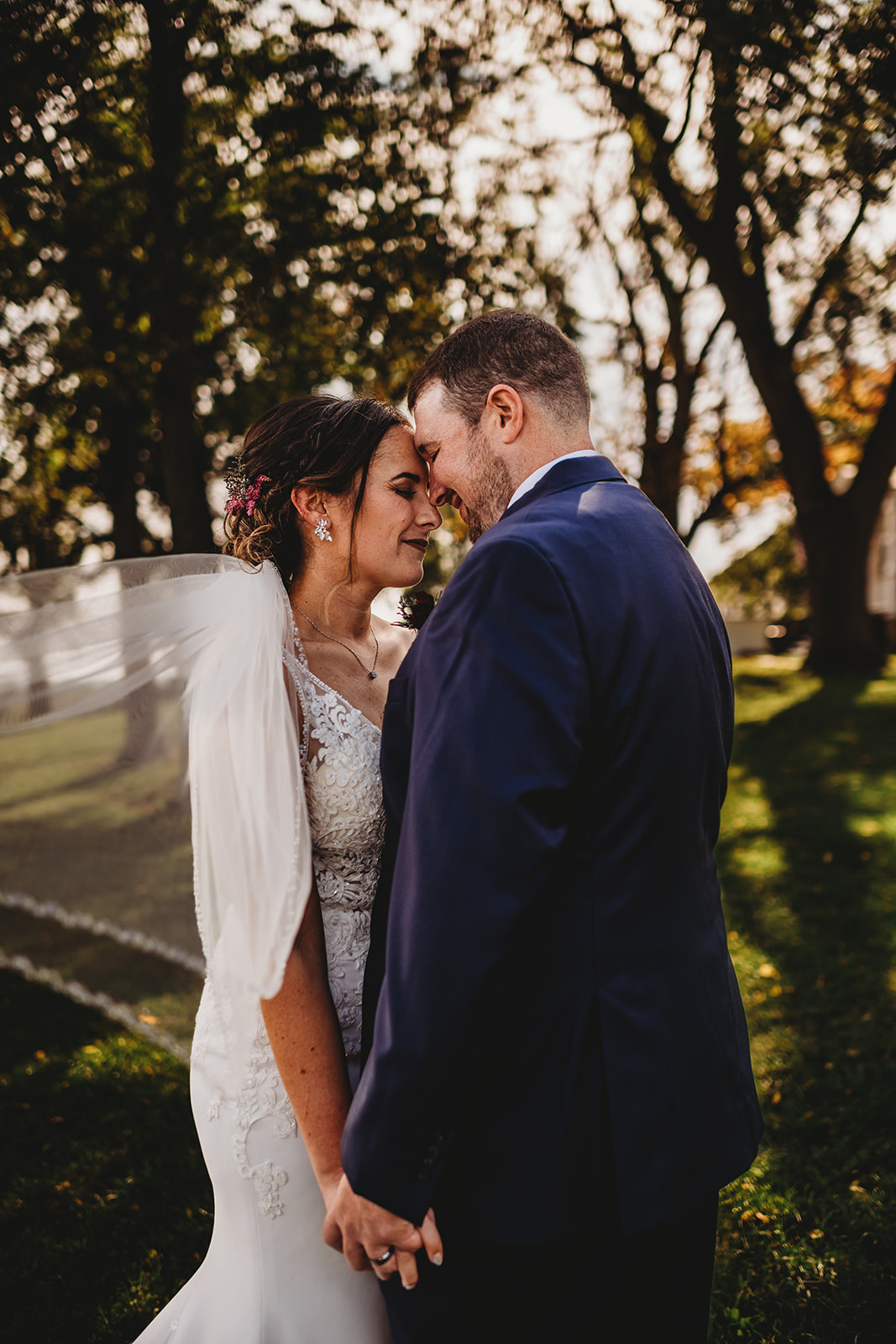 Baltimore wedding with bride and groom holding hands and leaning their heads in to one another romantically