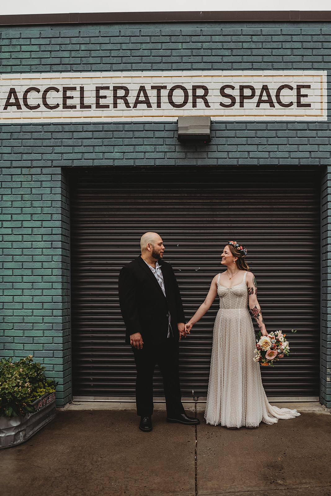 Baltimore wedding photographer captures bridal photo of bride and groom holding hands outside of the Accelerator Space Baltimore wedding venue