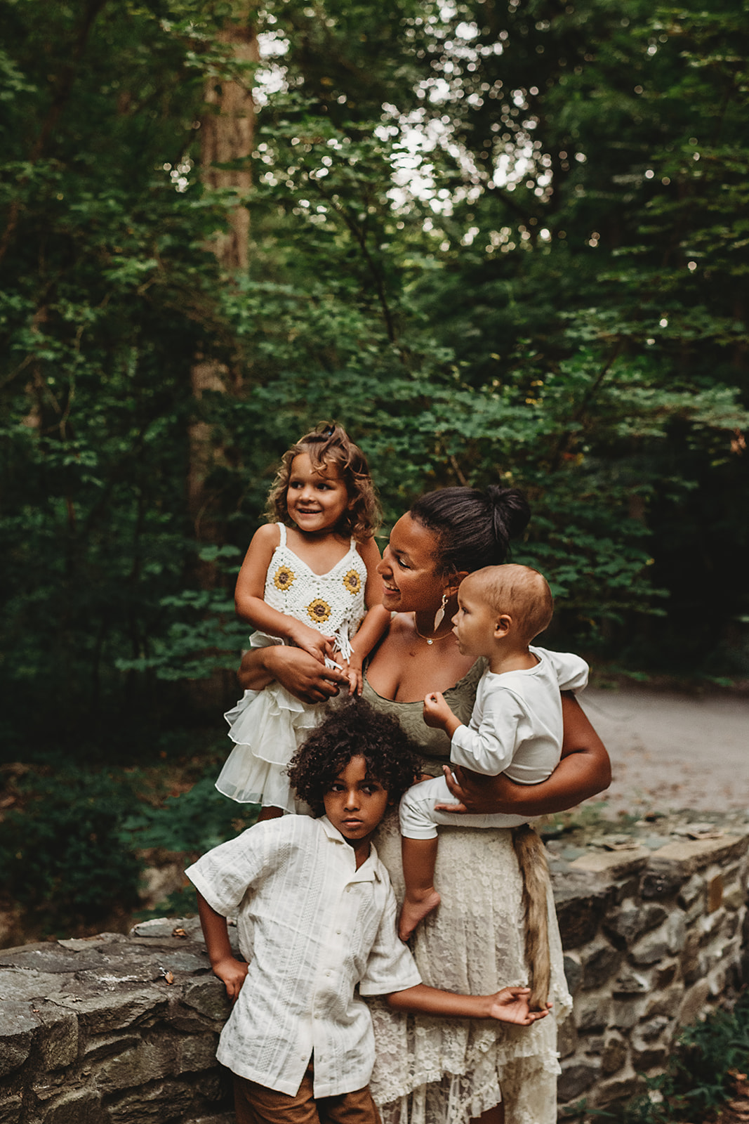 outdoor family photo in Maryland with mother and children standing together next to a stone wall